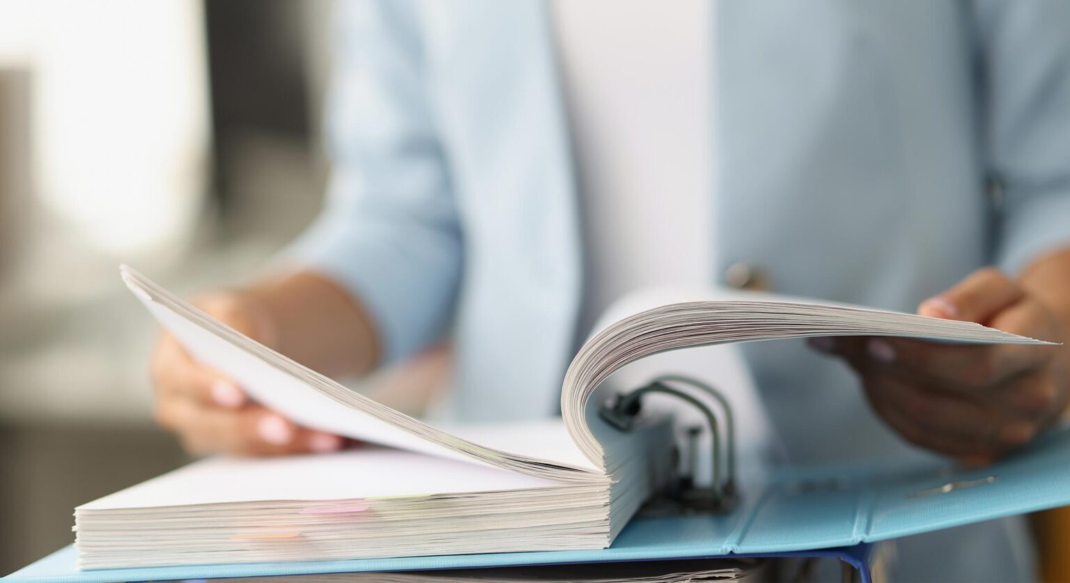 A woman flipping through a large file folder