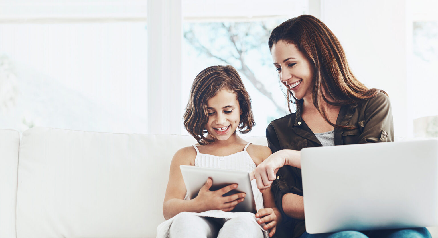 A mother working while helping her young daughter with her homework