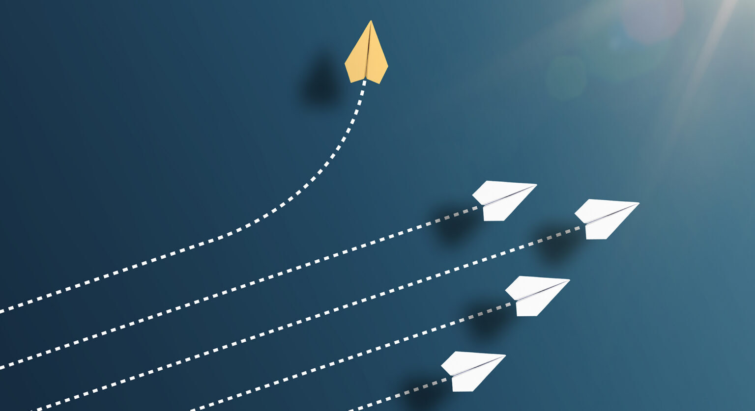 Five paper planes -- four white, one yellow. The four white paper planes fly straight ahead while the yellow paper plane turns