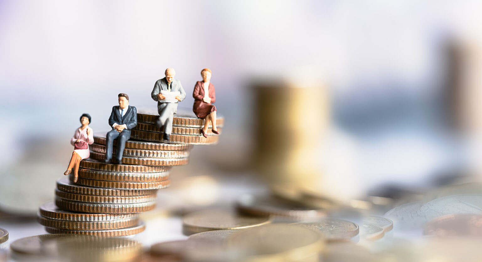 Small figures of people sit atop a pile of coins