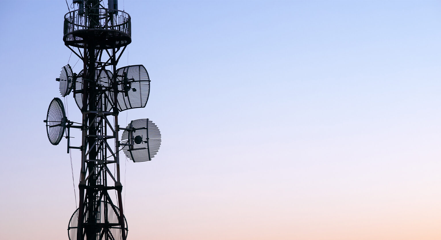 A communication mast in front of a setting sun
